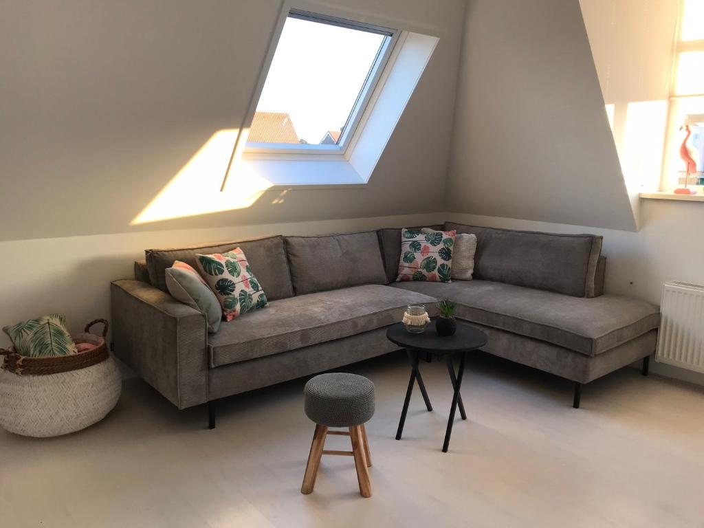 sala de estar con sofá y ventana en Dorpsweg 18 nummer 7, en Callantsoog