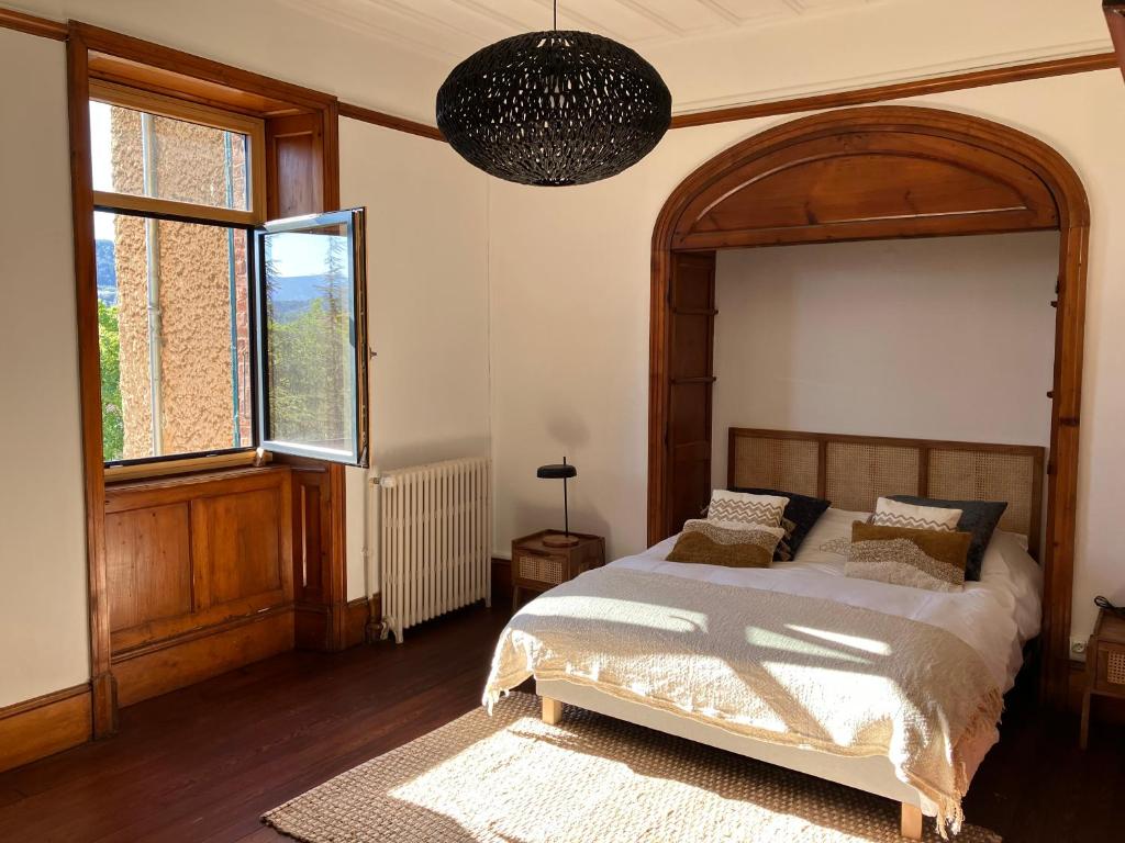 a bedroom with a large bed and a large window at O'Cottage double jardin in Annonay