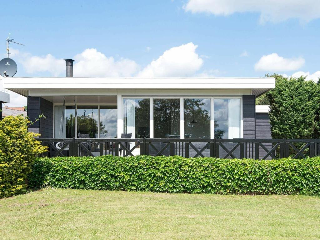 une maison avec de grandes fenêtres et une clôture dans l'établissement Comfortable Holiday Home in B rkop with Terrace, à Børkop