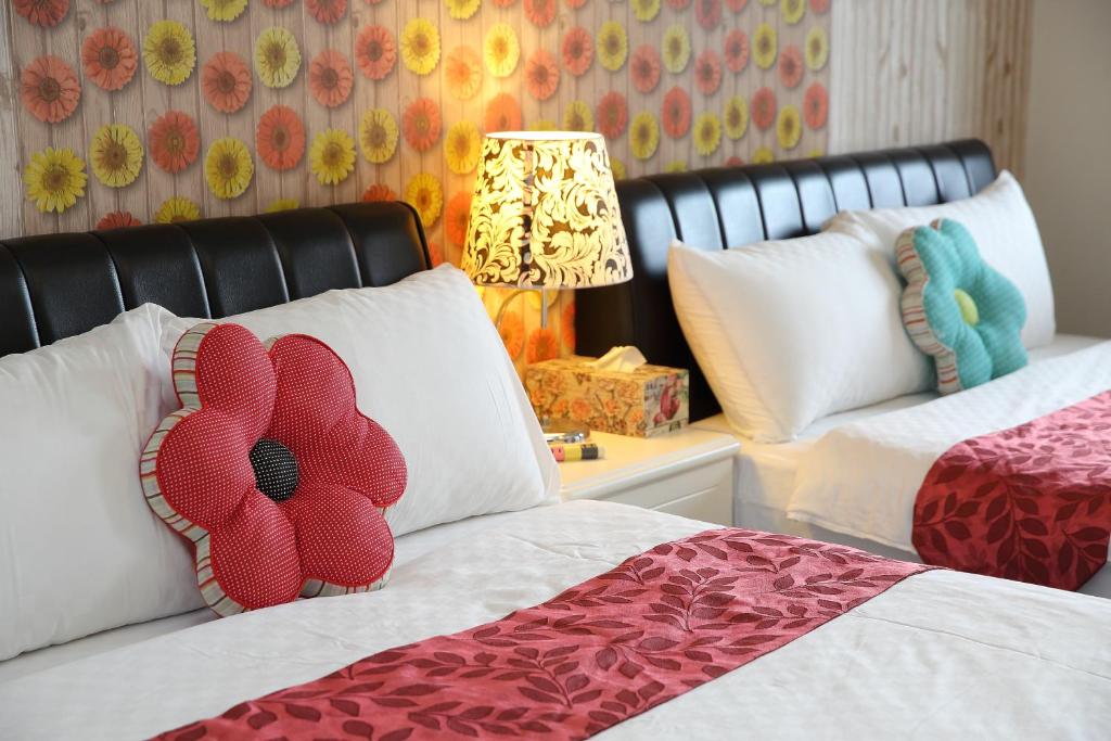 a bedroom with two beds with flowers on the pillows at Fish House Hostel in Wujie