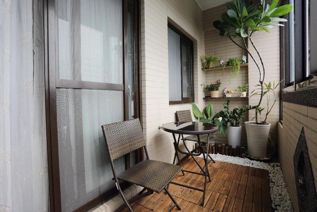 a small balcony with two chairs and a table at Fish House Hostel in Wujie