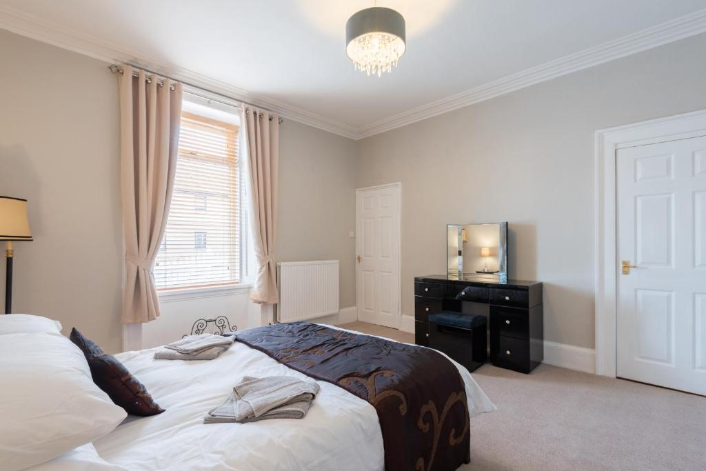 a bedroom with a bed and a dresser and a window at Scotston Villa - 5 bedroom house with hot tub in Forfar