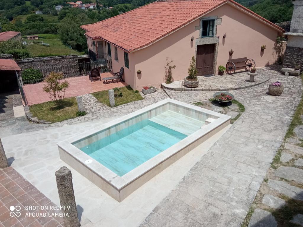 a swimming pool in front of a house at Galicia in Forcarei