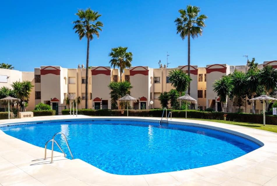 basen przed budynkiem z palmami w obiekcie Riviera Apartment Mijas Costa w Maladze
