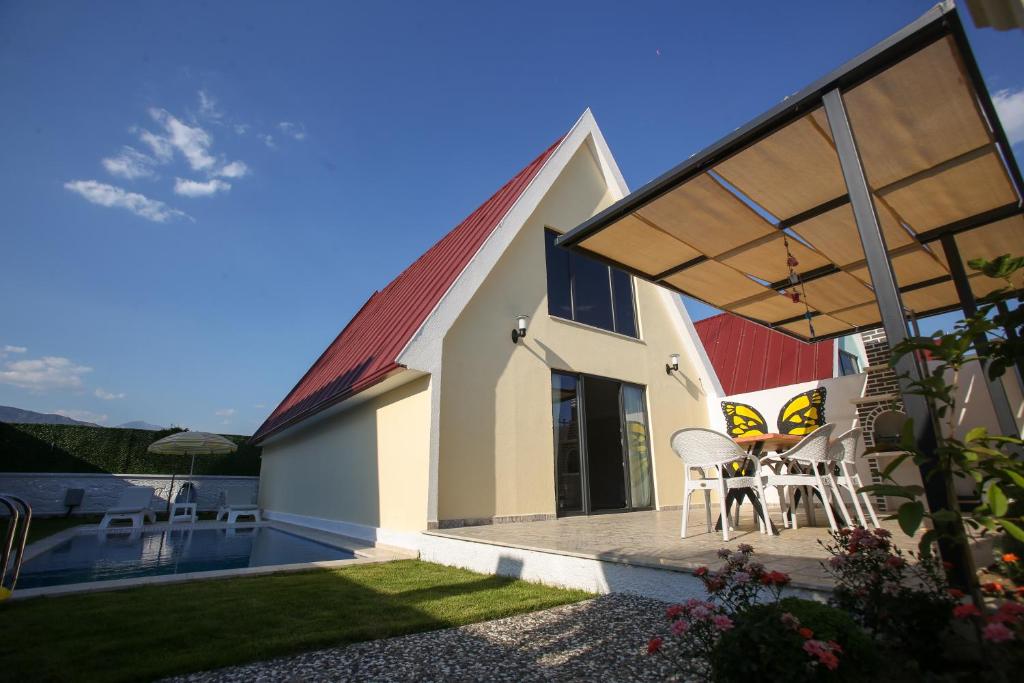 ein Haus mit einer Terrasse mit einem Tisch und Stühlen in der Unterkunft Vega Villalari in Fethiye