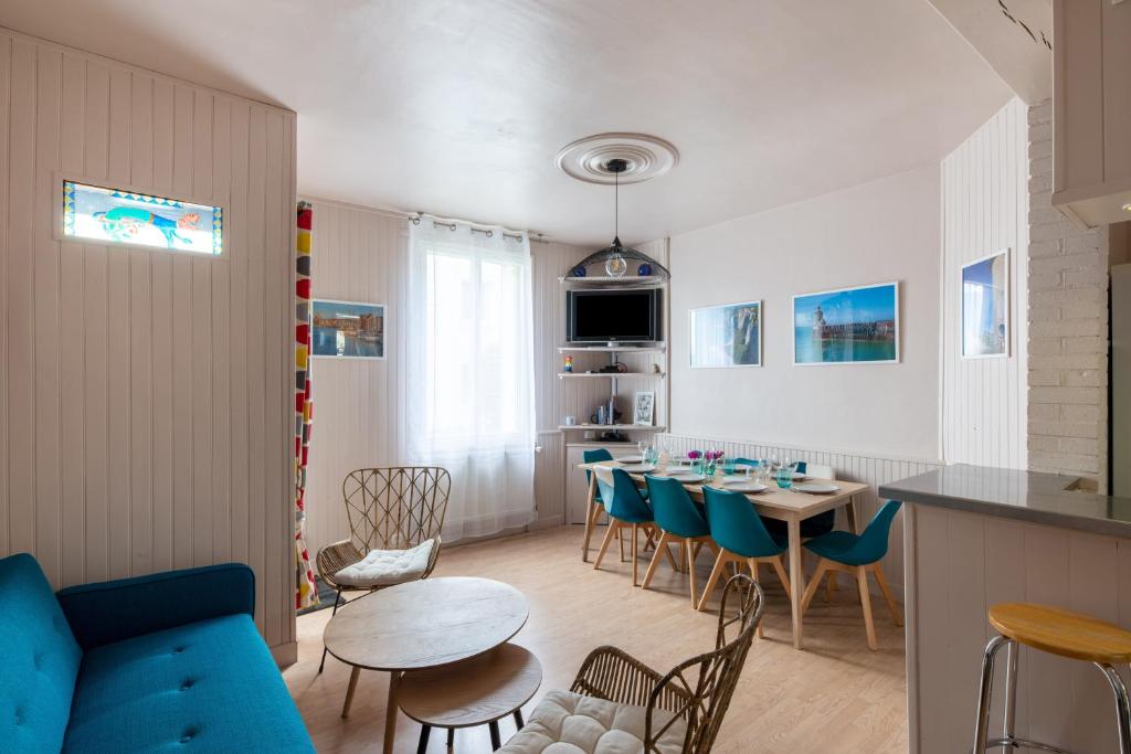 een woonkamer met een blauwe bank en een tafel bij L'Atelier du Pêcheur in Fécamp