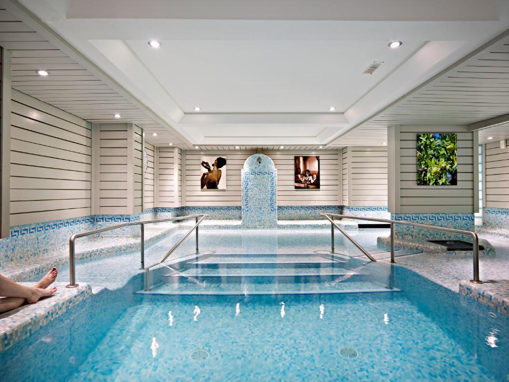 a swimming pool with a tub in a building at Hotel Le Morgane in Chamonix-Mont-Blanc