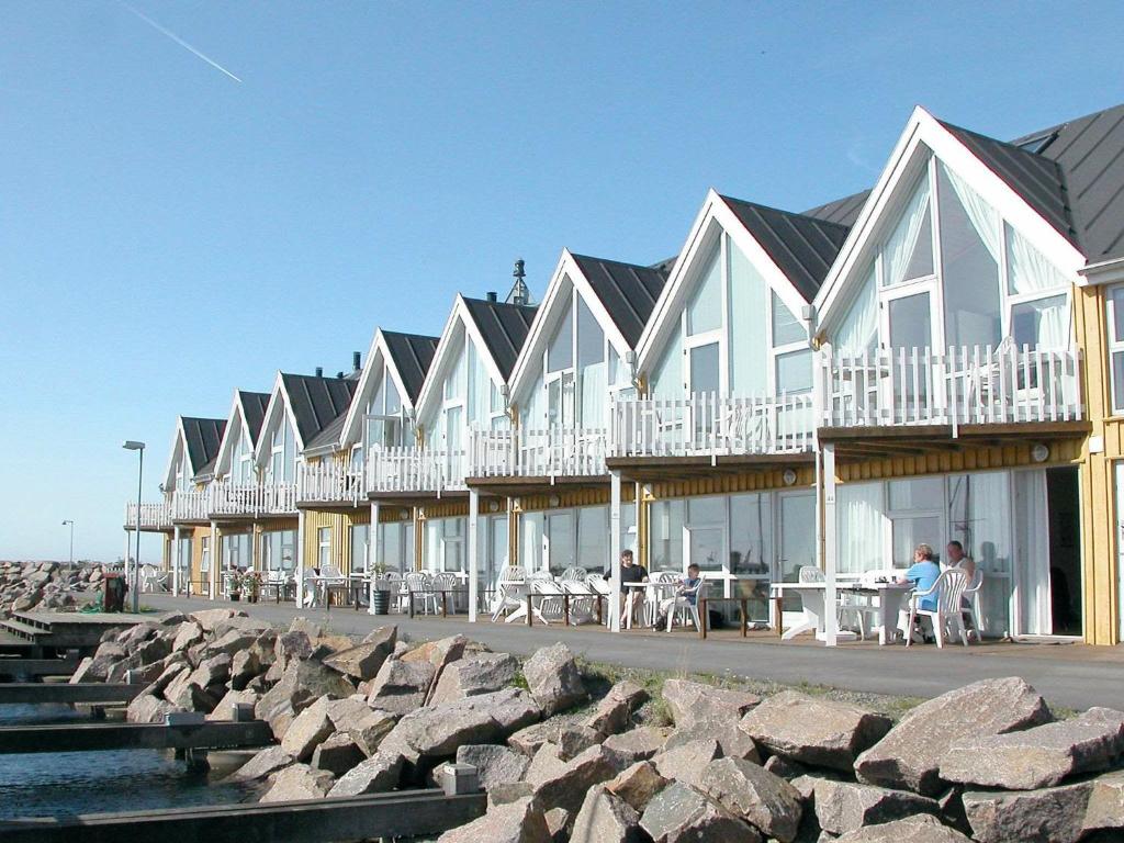 Hasle的住宿－6 person holiday home in Hasle，海滩上一排配有桌椅的房屋
