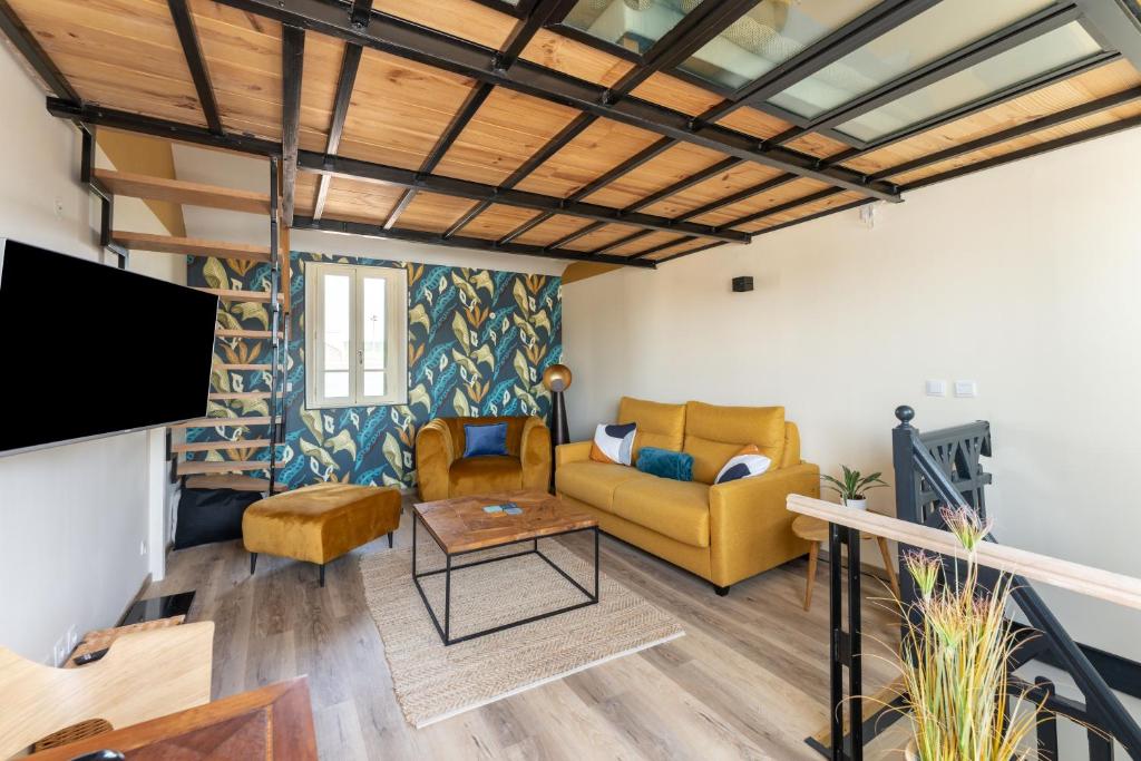 a living room with a couch and a tv at Josianne in Mers-les-Bains