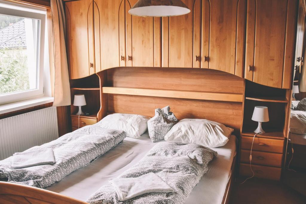 2 camas en una habitación con paredes de madera y ventana en Pension s'Platzl Stuhleck en Spital am Semmering