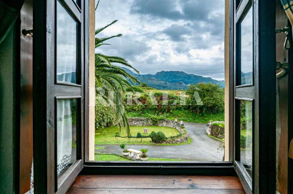 an open window with a view of a garden at Casa Rural Carmen 4 in Collera