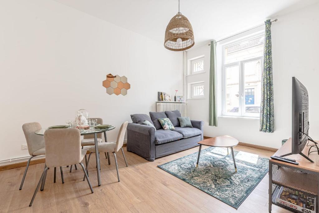 a living room with a couch and a table at Le Grain de Sable in Thionville