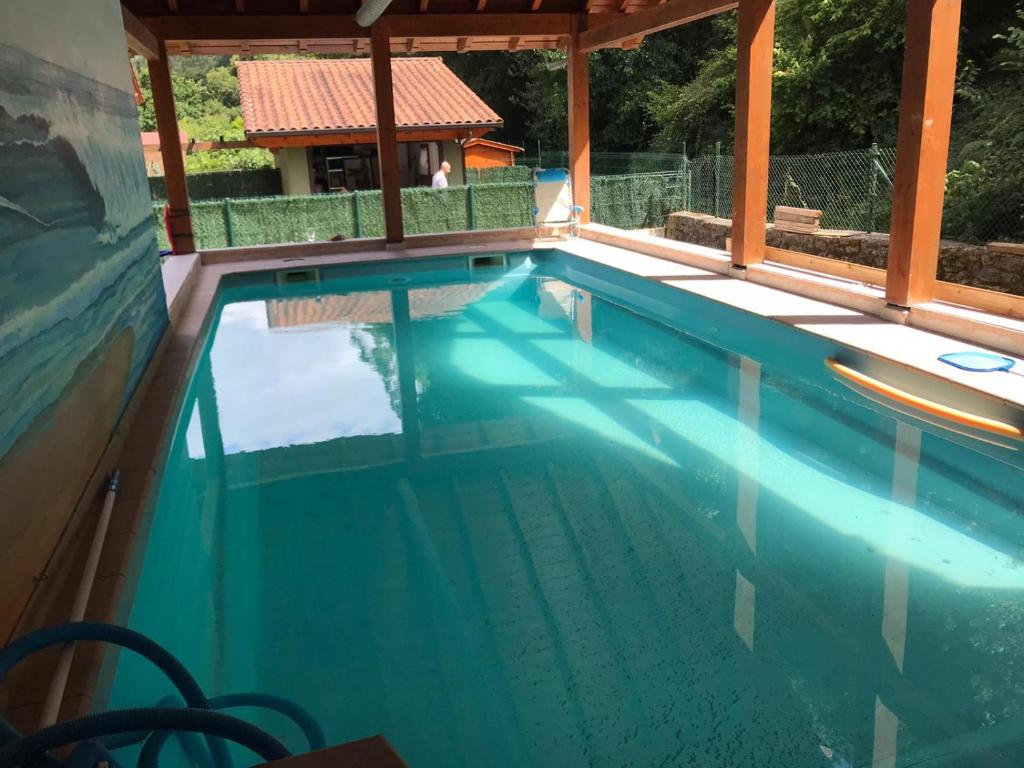 una piscina con acqua blu in una casa di La Casa Malvarrosa ad Ampuero