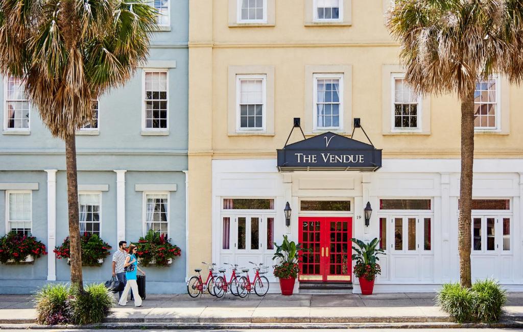 a woman walking in front of a building with a red door at The Vendue, Downtown Art Hotel in Charleston