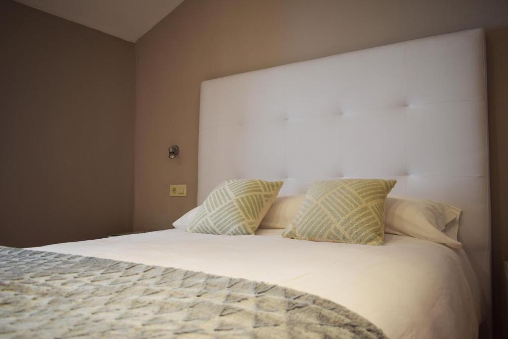 een slaapkamer met een wit bed met 2 kussens bij CASA PETRA in Morella