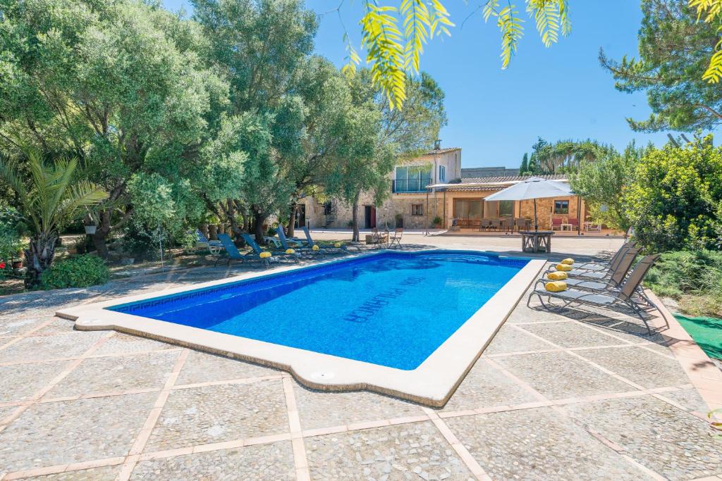 una piscina in un cortile alberato e una casa di Villa SON PALANCA a Sineu