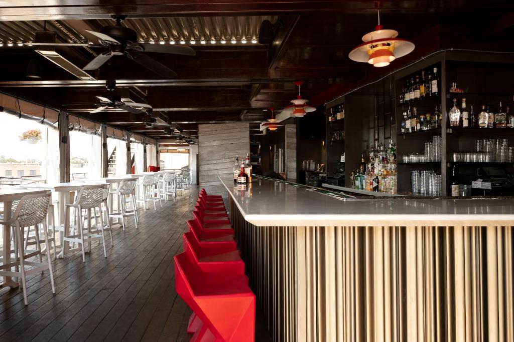 a bar with red seats in a restaurant at The Vendue, Downtown Art Hotel in Charleston