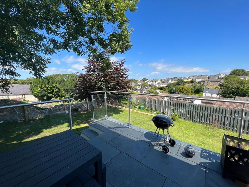 a grill sitting on top of a patio at Orchard Lodge -Coastal Retreat, new build, village views, private garden and terrace in Saint Brides Major