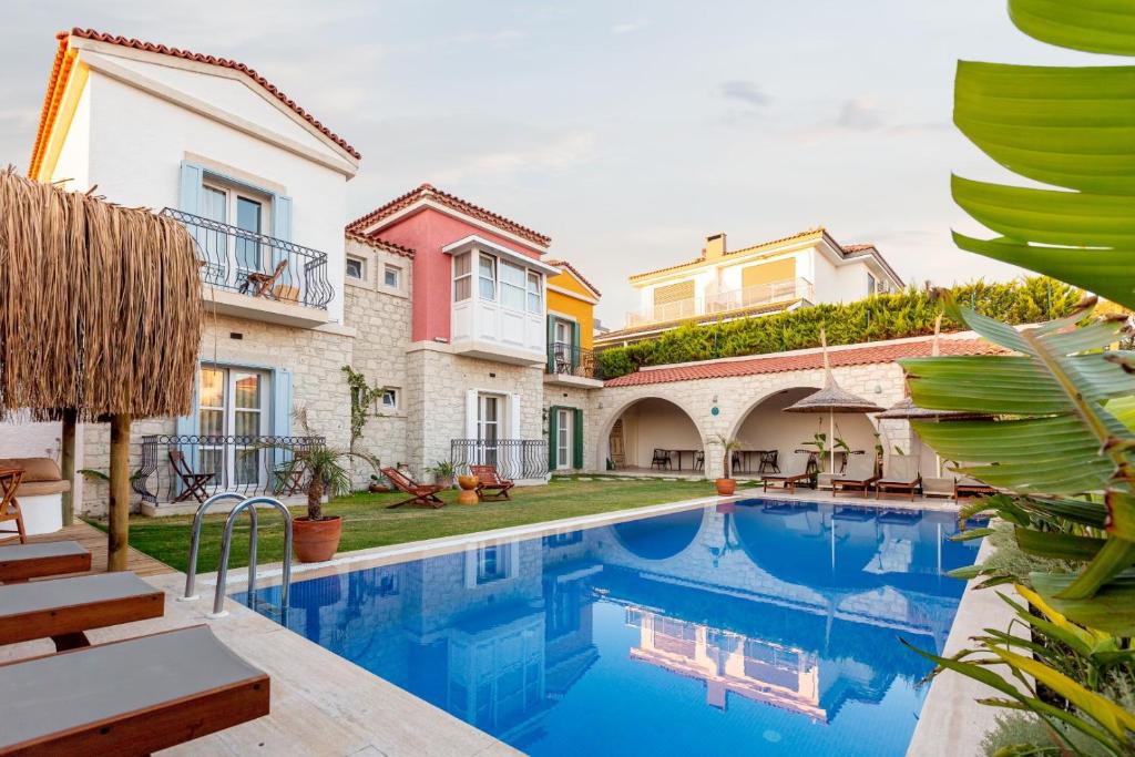 a villa with a swimming pool and a yard at Lika Alacati in Alaçatı