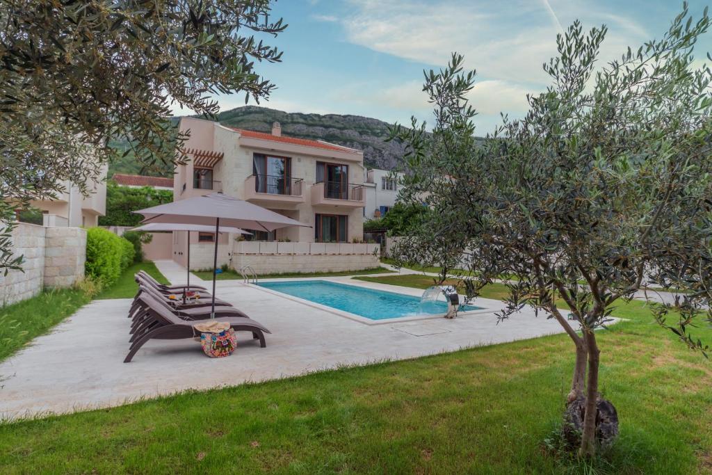 eine Villa mit einem Pool und einem Haus in der Unterkunft Villa Forte Mare in Petrovac na Moru