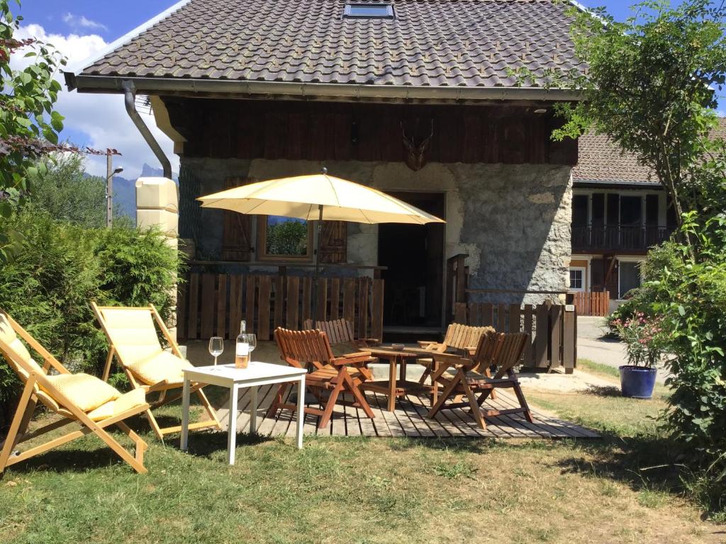 patio ze stołem, krzesłami i parasolem w obiekcie La cabane de Blanche entre lac et montagne w mieście Verchères