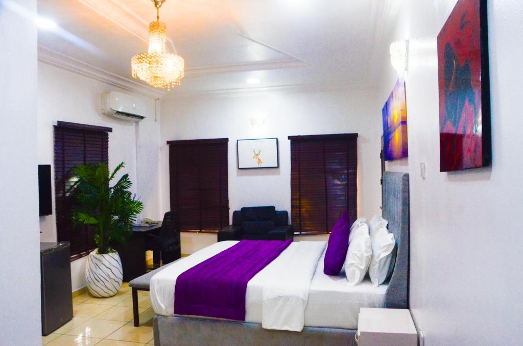 a bedroom with a large bed with purple sheets at J Gibson Hotel in Lagos