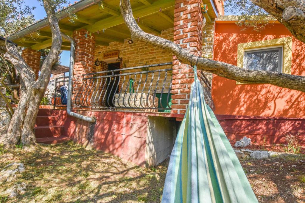 a porch of a brick house with a hammock at House Luce in Neviđane
