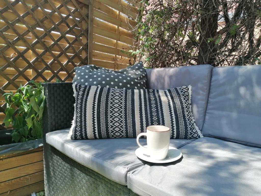 a cup of coffee sitting on a bench with pillows at El estudio del Duero in Tordesillas