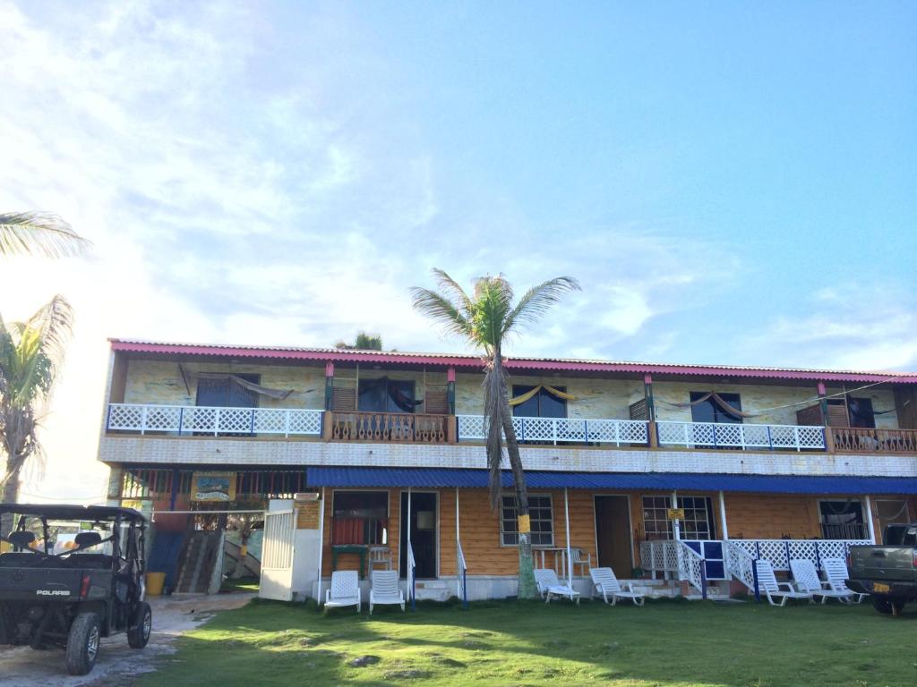 a building with a palm tree in front of it at Yellow Moon Guesthouse & Apartments in San Andrés