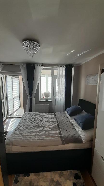 1 cama grande en un dormitorio con lámpara de araña en Kwatery prywatne en Międzyzdroje
