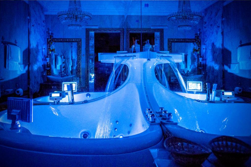 B&Boutique Lamezia Terme في لاميزيا تيرمي: حمام أزرق مع مغسلتين وحوض استحمام