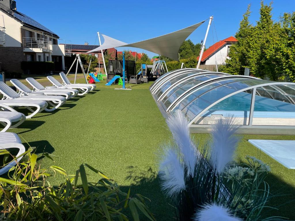 a row of white lounge chairs on a lawn at SIEDEM WYDM in Rowy