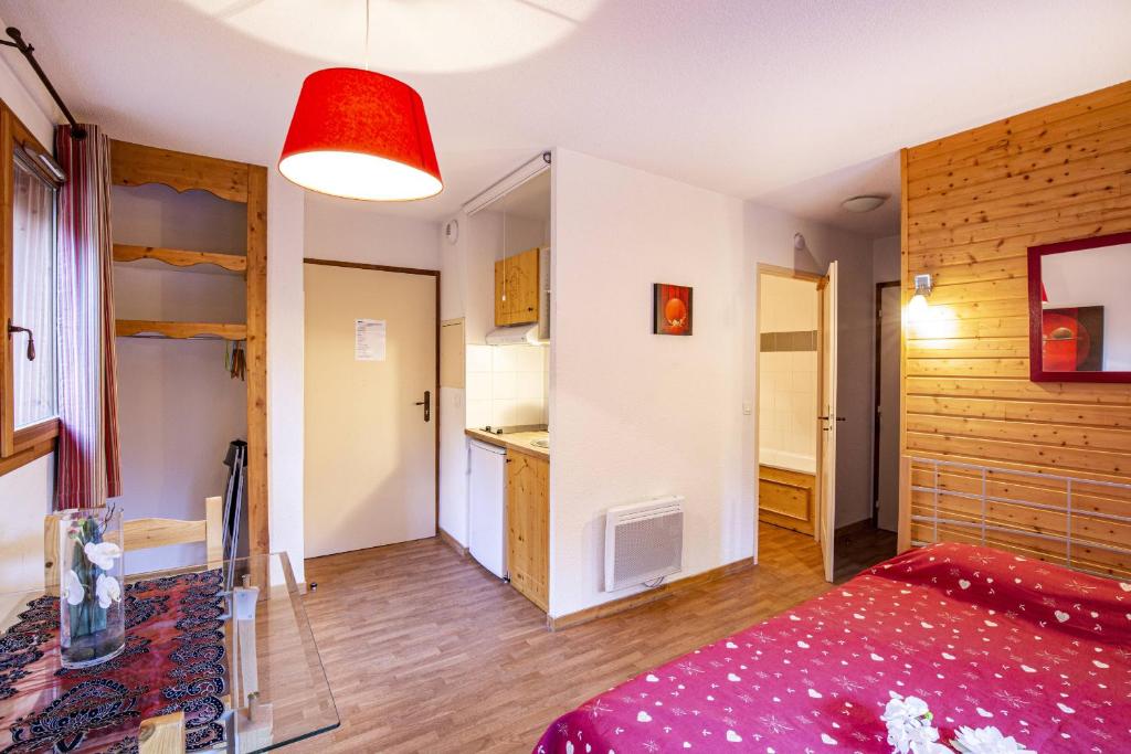 een grote kamer met een bed en een keuken bij Le Hameau SPA & PISCINE studio 2 pers by Alpvision Residences in Orelle