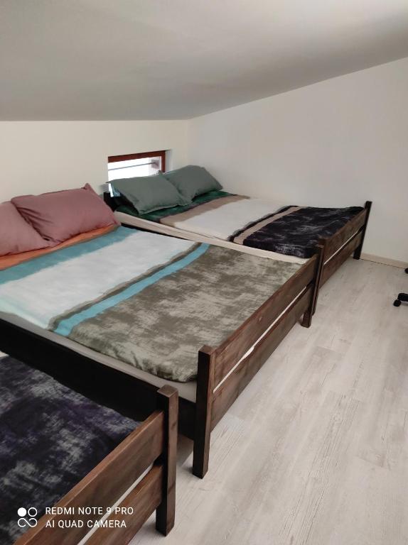 two twin beds in a room with wooden floors at Apartma Izola in Izola