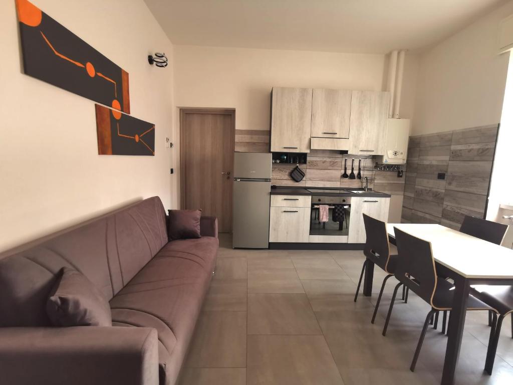 ein Wohnzimmer mit einem Sofa und einem Tisch sowie eine Küche in der Unterkunft Uro's Home in Lonate Pozzolo