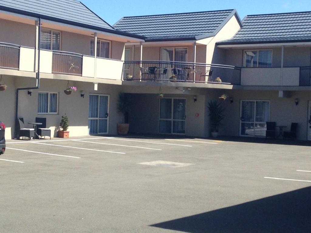 un aparcamiento vacío frente a un edificio en ASURE Amalfi Motor Lodge, en Christchurch