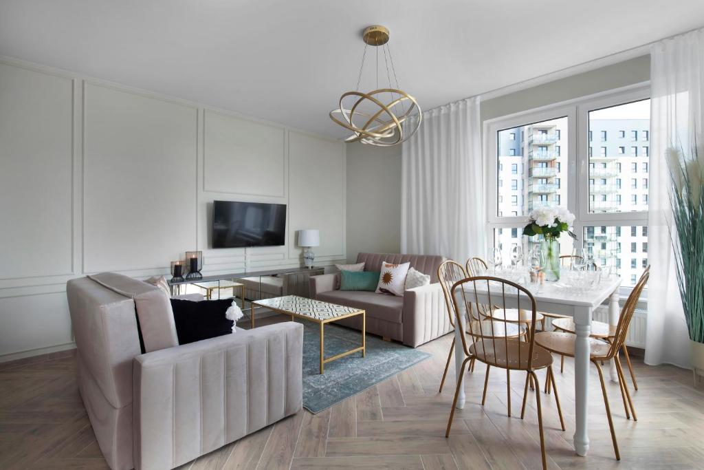 una sala de estar con un sofá y una mesa en Elite Apartments Marine Cztery Oceany, en Gdansk