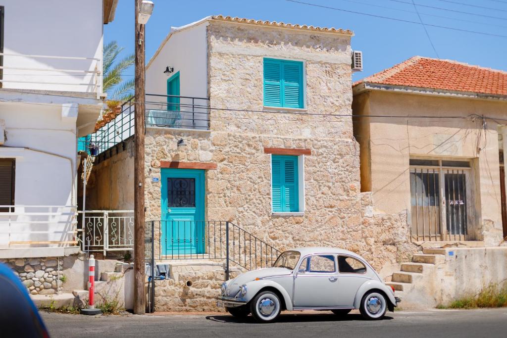 a white car parked in front of a building at Santa Napa Guest House in Famagusta