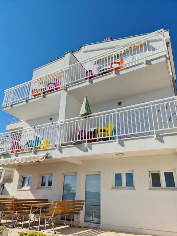 un edificio con balcón con sillas y mesas en Apartments Mediteraneo, en Klek