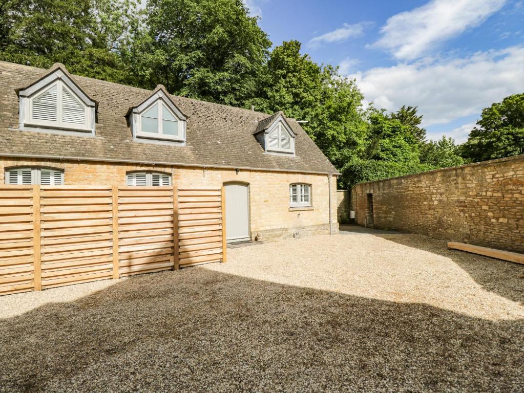 a house with a garage with a fence at The Coach House in Tetbury