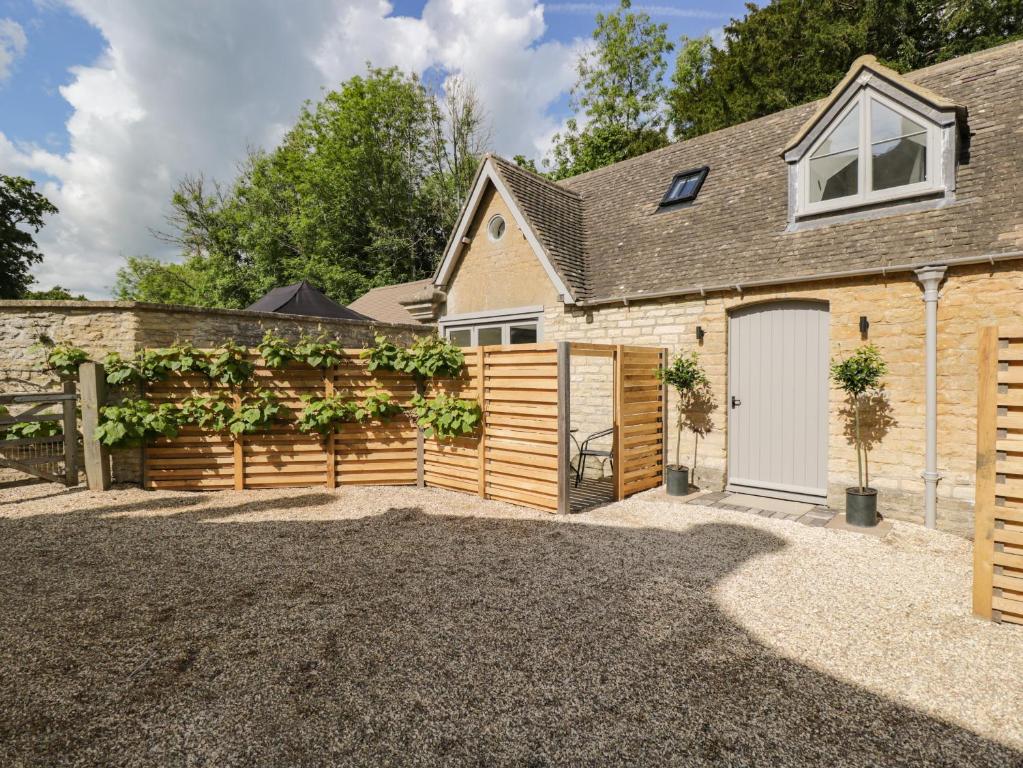 a house with a fence and a garage at The Hayloft in Tetbury
