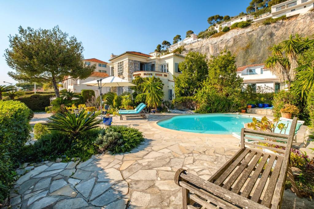 - une piscine avec 2 bancs en bois dans une cour dans l'établissement Exclusive!Villa Eolienne:Vue Mer,Piscine, à Nice
