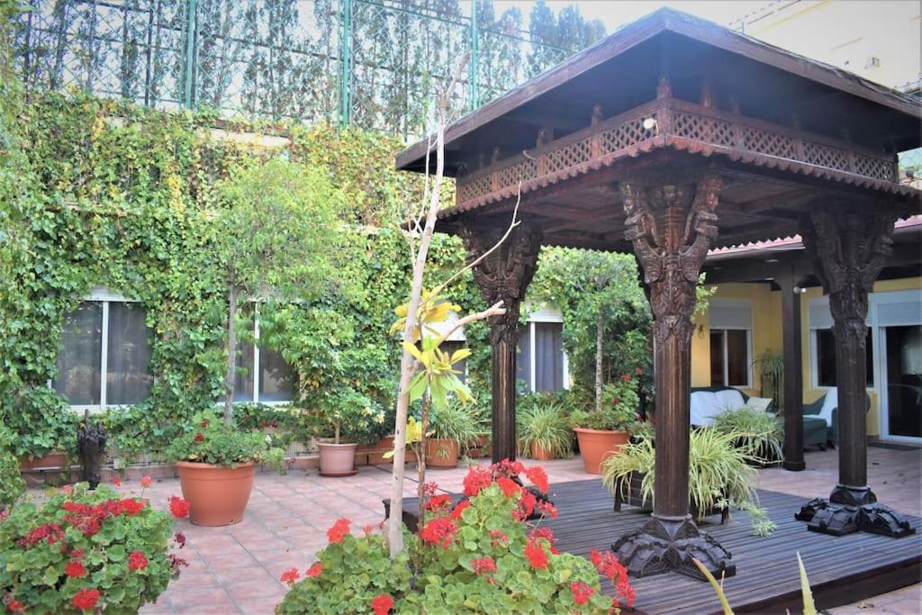 un cenador de madera con flores en un patio en Casa con terrazas, en Zaragoza
