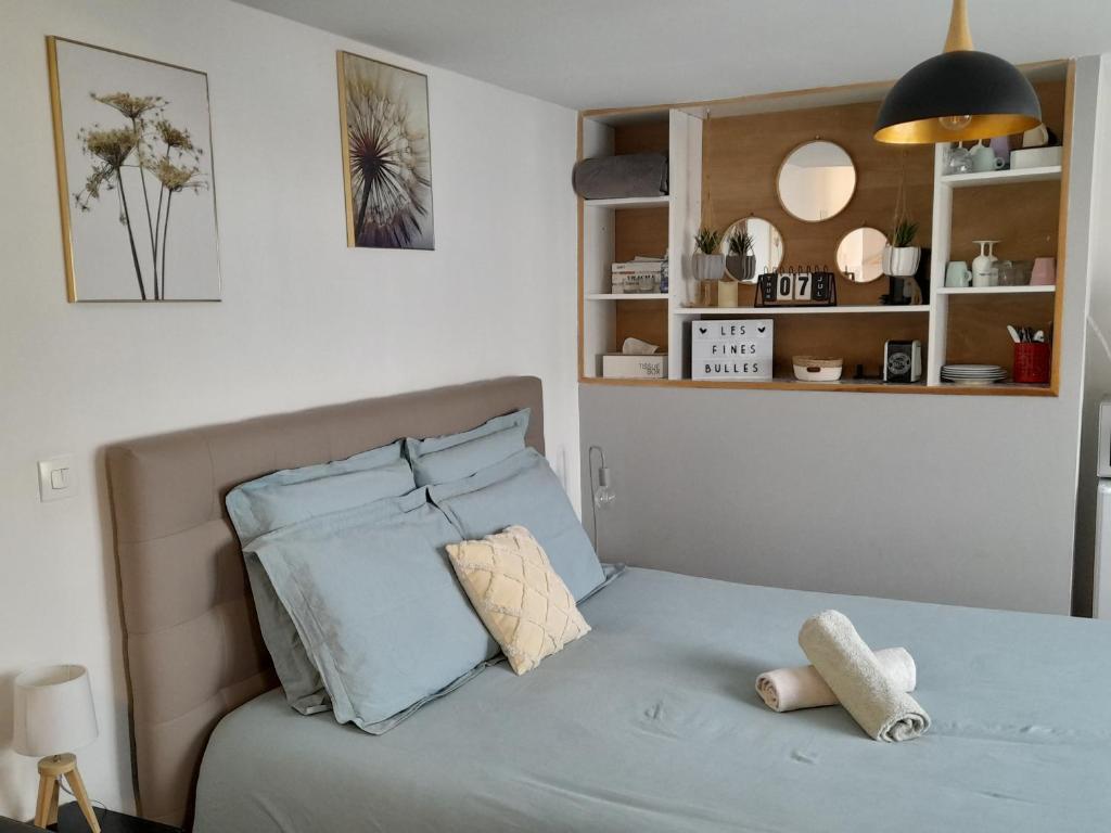 Les Fines Bulles & spa في Bourseville: غرفة نوم بسرير وملاءات ووسائد زرقاء