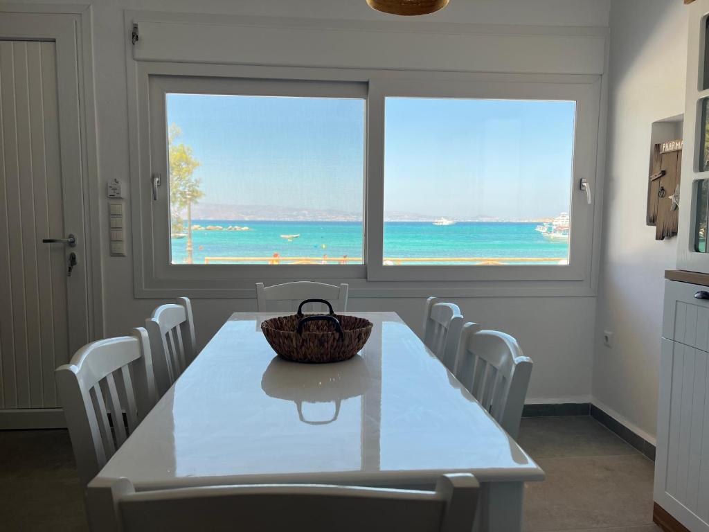 una sala da pranzo con tavolo e sedie e vista sull'oceano di Villa stou Chiou ad Agia Anna Naxos