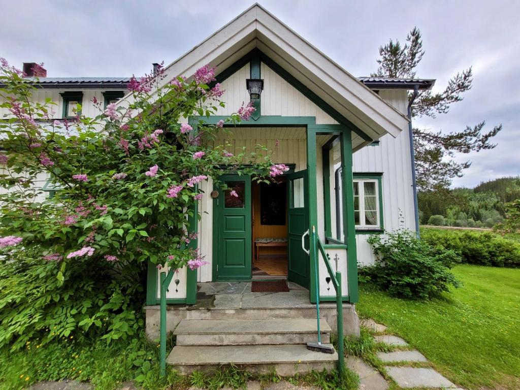 una puerta verde en una casa blanca con flores en Landlig leilighet en Landsem