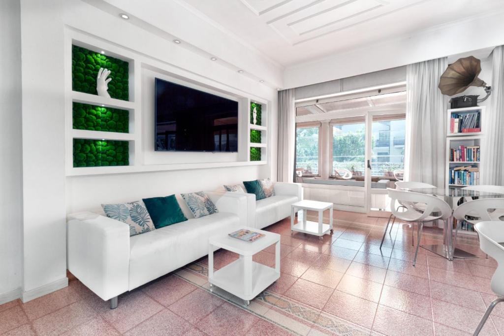 a living room with a white couch and a table at Hotel Sant'Agata in SantʼAgata sui Due Golfi