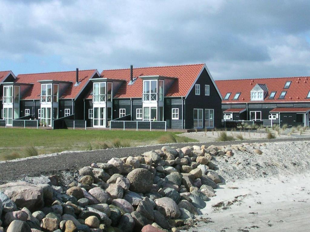 eine Reihe von Häusern mit roten Dächern und Felsen in der Unterkunft 6 person holiday home in Juelsminde in Juelsminde