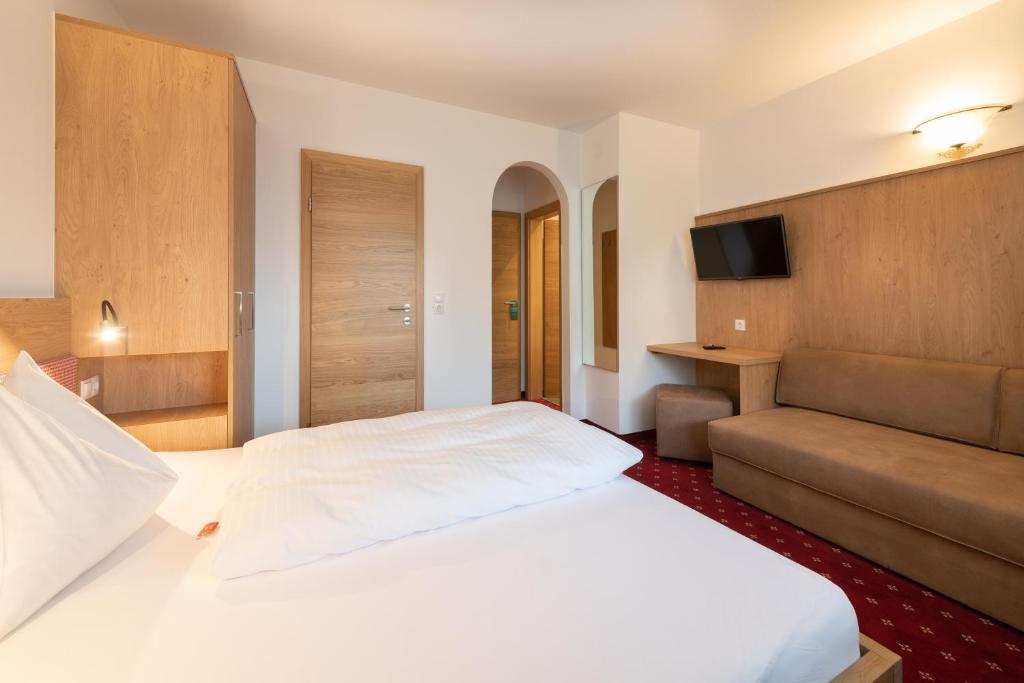 Postel nebo postele na pokoji v ubytování Hotel Gasthof Kröll - inkl Nationalpark-Karte, 1 x Grossglockner Hochalpenstraße kostenlos, verschiedene Bergbahnen kostenlos, Badesee kostenlos, Bus & Zug kostenlos, regionale Küche