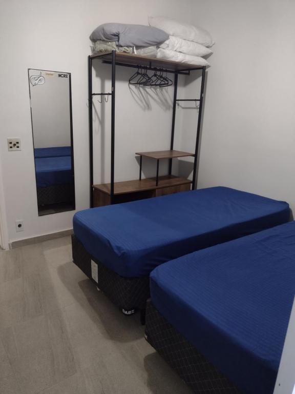 a room with two beds and a bunk bed at Cello´s Apartamento in Guarujá